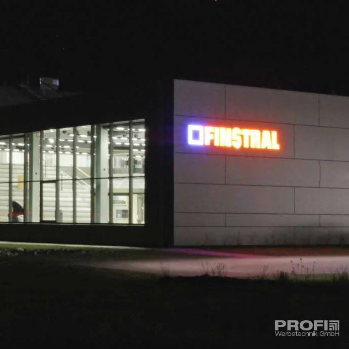 LED-Leuchtbuchstaben-Anlage an Firmenfassade bei Nacht - Hell beleuchtet